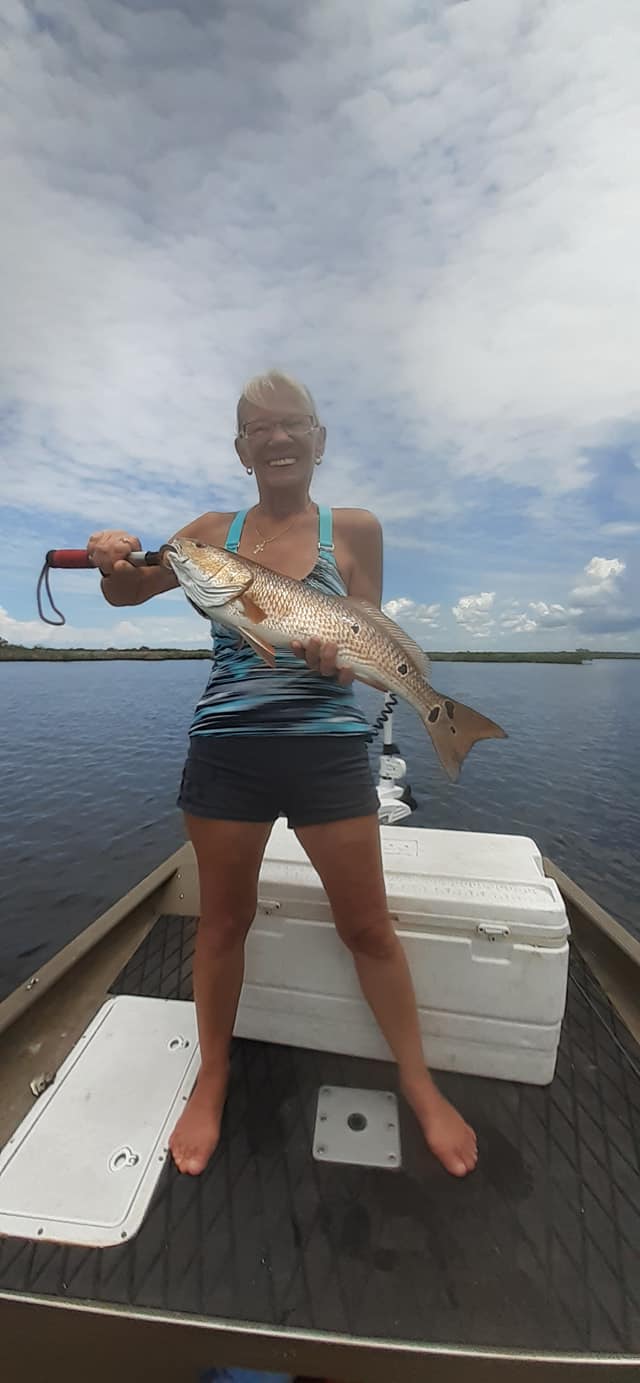 Laughing woman holding monster redfish