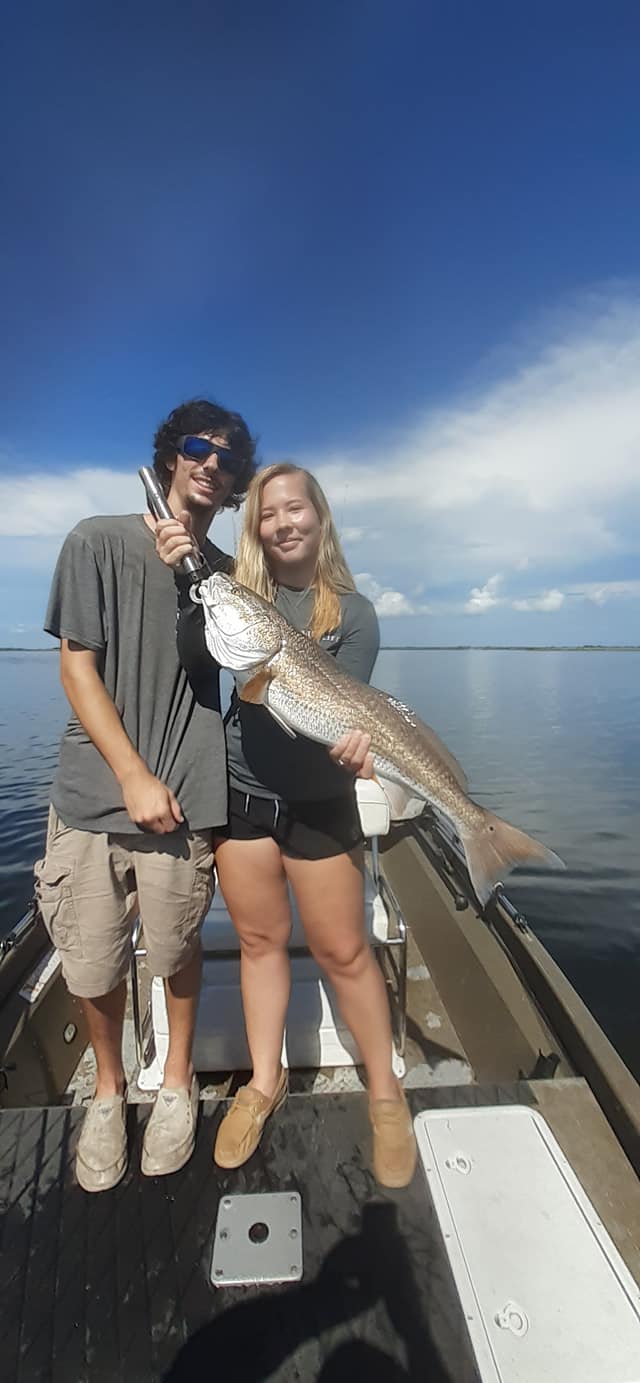 Couple posing with their monster redfish